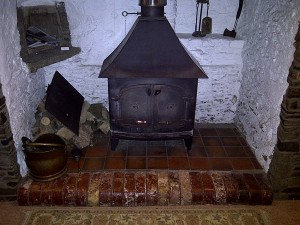 The existing stove - A very old Yeoman Woodburner. Very inefficient Solid doors The chimney is not lined and has caught fire in the past.